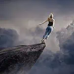 Eine Frau steht auf einem Felsvorsprung und springt ins Ungewisse in Richtung Schloss